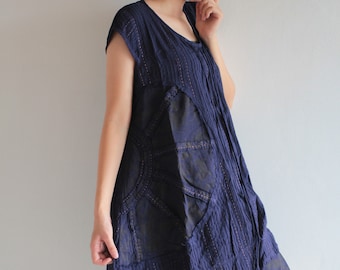May include: A navy blue, sleeveless dress with a layered, asymmetrical design. The dress has a textured, crinkled fabric and a subtle shimmer.