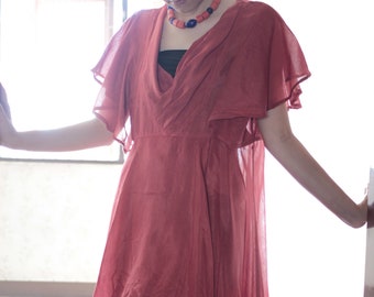Vestido de seda asimétrico con cuello vuelto y mangas acampanadas.