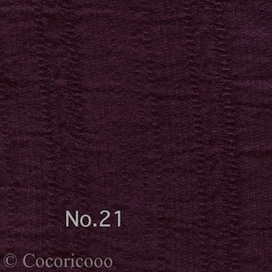 May include: A close-up of a dark purple fabric with a textured woven pattern. The fabric has a subtle sheen and a soft, drapey feel. The text "No. 21" is printed in white on the fabric.