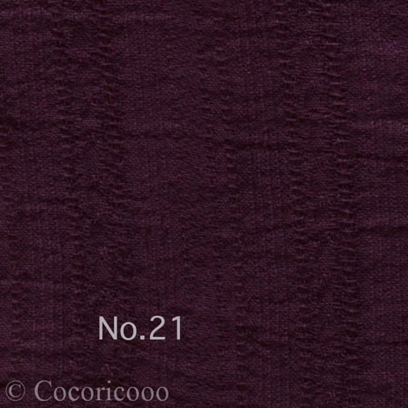 May include: A close-up of a dark purple fabric with a textured woven pattern. The fabric has a subtle sheen and a soft, drapey feel. The text "No. 21" is printed in white on the fabric.