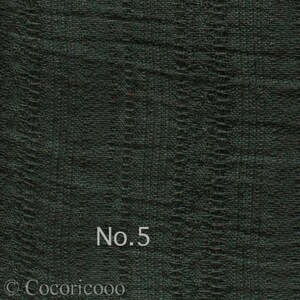 May include: A close-up of a dark green fabric with a textured woven pattern. The fabric has a subtle sheen and a slightly rough texture. The text "No. 5" is printed in white on the fabric.
