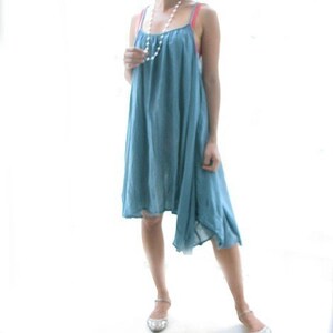 May include: A light blue sleeveless dress with a slightly asymmetrical hemline. The dress is made of a soft, flowing fabric and has a relaxed fit.