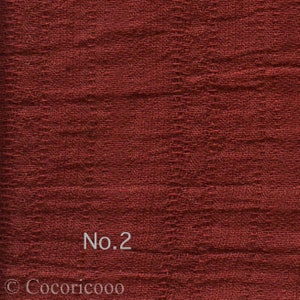 May include: Close-up of a textured, reddish-brown fabric with the text "No.2" printed on it.