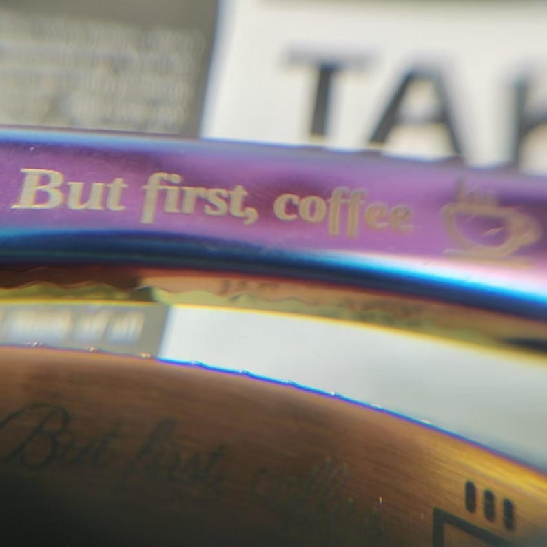 May include: A stainless steel reusable straw with a rainbow iridescent finish. The straw has the text "But first, coffee" engraved on it.