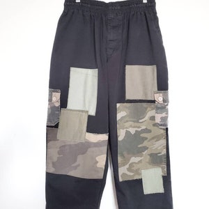Peut inclure: Pantalon cargo noir avec un design patchwork en tissu camouflage et vert uni.