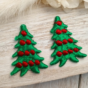 May include: Two green felt Christmas tree ornaments with red felt ornaments sewn on.