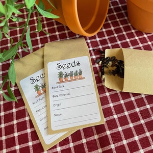 May include: Two brown paper envelopes with labels that say "Seeds" and have a drawing of a row of potted plants. The labels have blank lines for seed type, date collected, origin, and notes. One envelope is open and has dark brown seeds inside.