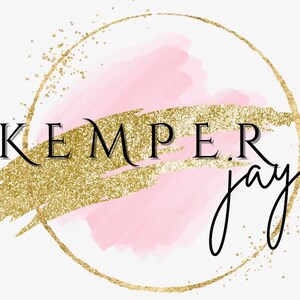 Puede incluir: Un círculo dorado con un fondo de acuarela rosa y purpurina dorada. El texto "KEMPER jayne" está escrito en negro.