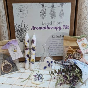 May include: Aromatherapy kit with dried flowers, candles, and a glass vase. The kit includes a simmer pot, potpourri, and a heart-shaped wax melt. The box has the text "Dried Floral Aromatherapy Kit".