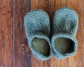 Puede incluir: Un par de zapatillas de crochet azul turquesa. Las zapatillas están hechas con un hilo grueso y tienen un diseño simple y clásico.