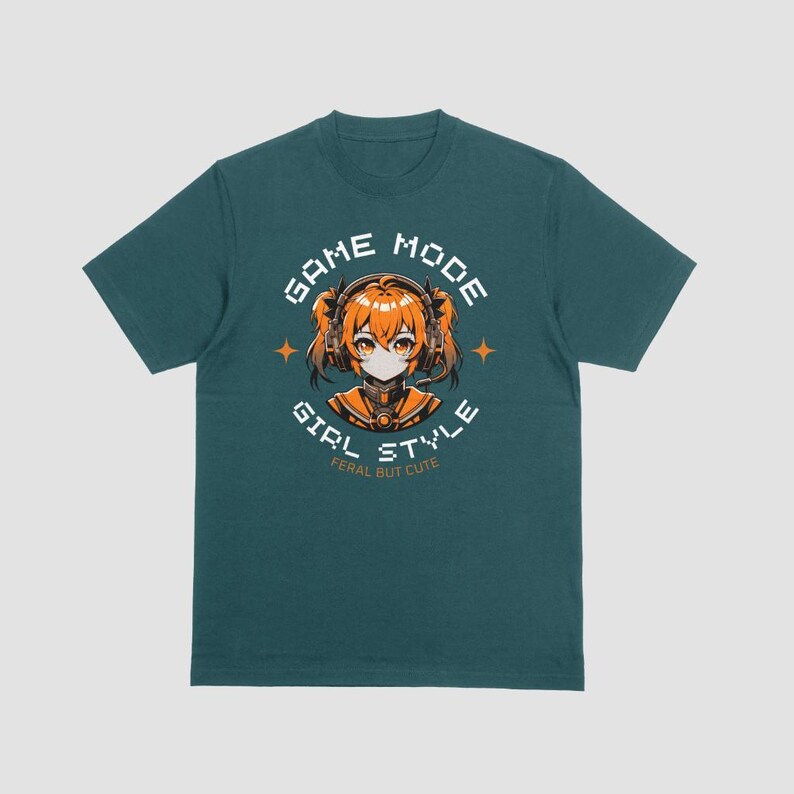 May include: Teal blue t-shirt with a white graphic of a girl with orange hair wearing headphones. The graphic says "Game Mode Girl Style Feral But Cute".