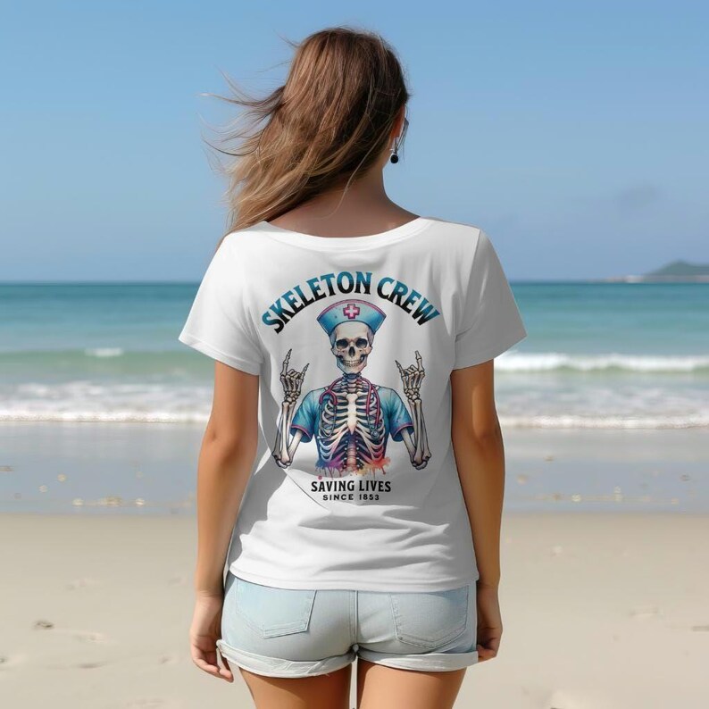 May include: White t-shirt with a colorful skeleton wearing a nurse's uniform and a hat with a red cross. The text "Skeleton Crew Saving Lives Since 1853" is printed on the back of the shirt.