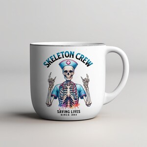 May include: White ceramic mug with a colorful illustration of a skeleton wearing a nurse's uniform and a stethoscope. The text "Skeleton Crew Saving Lives Since 1853" is printed on the mug.