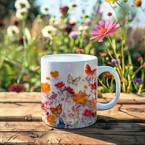 May include: White ceramic mug with a floral design featuring butterflies and flowers in shades of pink, orange, yellow, and green. The mug has a handle and is sitting on a wooden surface.