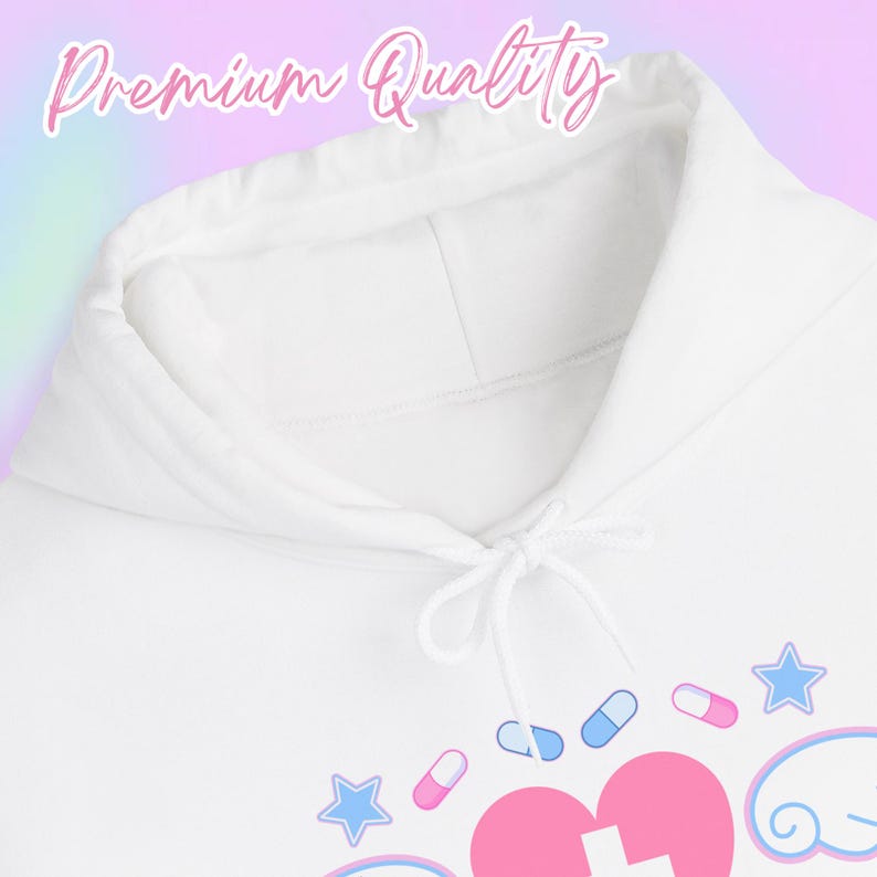 Pode incluir: Moletom branco com cord&atilde;o e um design gr&aacute;fico com um cora&ccedil;&atilde;o rosa, p&iacute;lulas e estrelas. O texto "Premium Quality" est&aacute; no topo. O moletom &eacute; feito de um material macio.