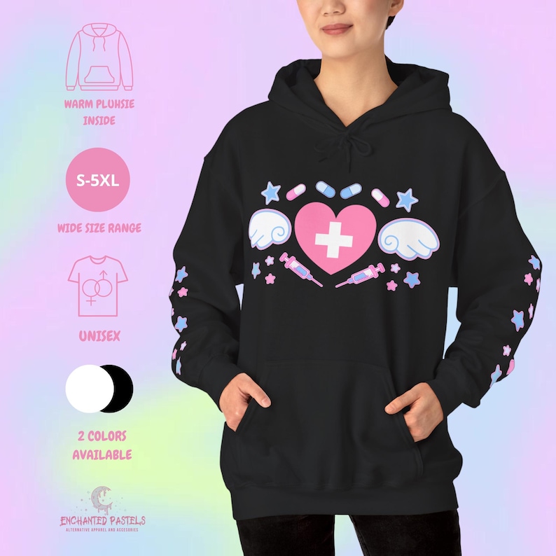 Pode incluir: Moletom unissex preto com um cora&ccedil;&atilde;o rosa e cruz, asas, estrelas, p&iacute;lulas e seringas. As mangas t&ecirc;m detalhes de estrelas. Texto: "S-5XL", "Unisex" e "2 cores dispon&iacute;veis".