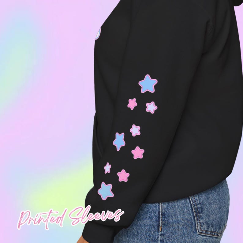 Pode incluir: Moletom preto com estampa de estrelas azul claro e rosa na manga. O texto "Printed Sleeves" est&aacute; escrito em it&aacute;lico na parte inferior da imagem. O fundo &eacute; um gradiente pastel.