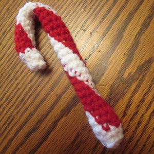 May include: A crocheted candy cane ornament with red and white stripes.