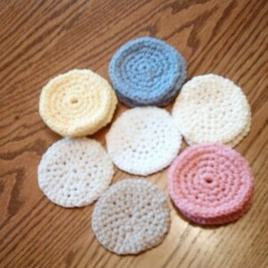 Peut inclure: Sept dessous-de-verre en crochet de diff&eacute;rentes couleurs, dont le jaune, le blanc, le bleu clair et le rose. Les dessous-de-verre sont circulaires et pr&eacute;sentent un motif en relief textur&eacute;.