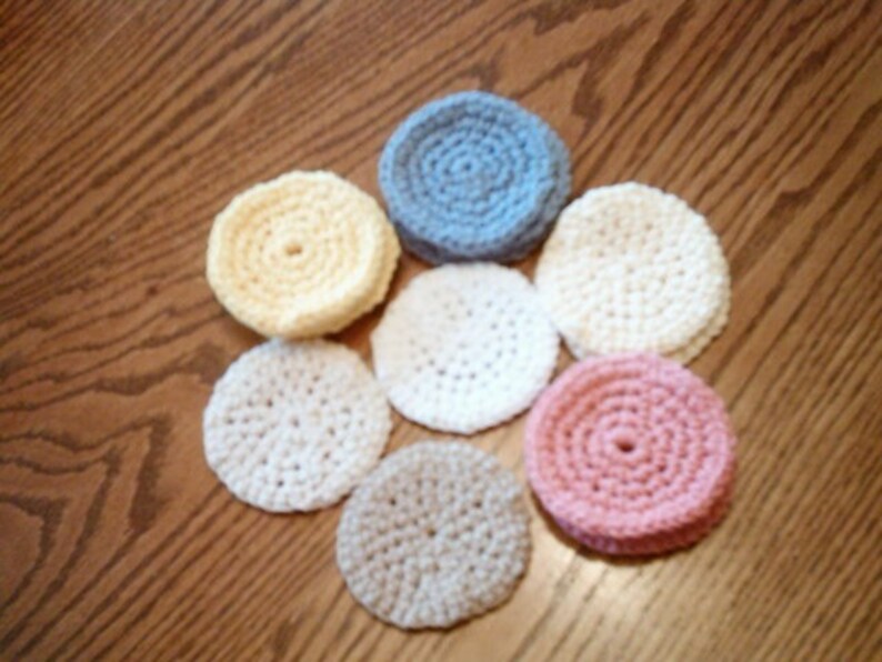 Peut inclure: Sept dessous-de-verre en crochet de diff&eacute;rentes couleurs, dont le jaune, le blanc, le bleu clair et le rose. Les dessous-de-verre sont circulaires et pr&eacute;sentent un motif en relief textur&eacute;.