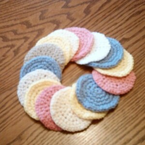 Peut inclure: Un ensemble de cercles en crochet de diff&eacute;rentes couleurs pastel, notamment rose, bleu, jaune et blanc. Les cercles sont dispos&eacute;s en cercle, cr&eacute;ant une couronne d&eacute;corative.