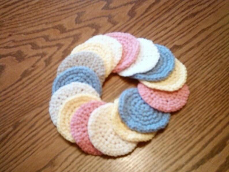 Peut inclure: Un ensemble de cercles en crochet de diff&eacute;rentes couleurs pastel, notamment rose, bleu, jaune et blanc. Les cercles sont dispos&eacute;s en cercle, cr&eacute;ant une couronne d&eacute;corative.