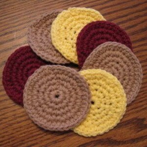 Peut inclure: Ensemble de huit dessous-de-verre en crochet de couleur jaune, marron et bordeaux. Les dessous-de-verre sont ronds et pr&eacute;sentent un design simple et textur&eacute;.