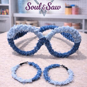 May include: A pair of denim-covered eyeglasses and two matching hoop earrings. The eyeglasses and earrings are made from strips of blue denim fabric. The text "Soul & Saw" is visible in the background.