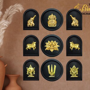 Puede incluir: Nueve adornos de pared decorativos con símbolos religiosos dorados sobre fondos negros. Los símbolos incluyen elefantes, una flor de loto, una vaca y otros diseños ornamentados. El texto "The Brass Dicrofts" está en la esquina superior derecha.