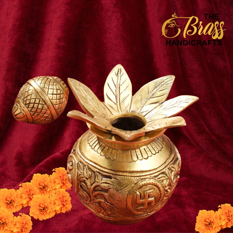 Peut inclure: Un pot artisanal en laiton dor&eacute; avec un couvercle en forme de lotus et un objet d&eacute;coratif en forme d'&oelig;uf. Le pot pr&eacute;sente des gravures complexes et un symbole Swastika. Le fond est un tissu rouge fonc&eacute;, avec des fleurs oranges.