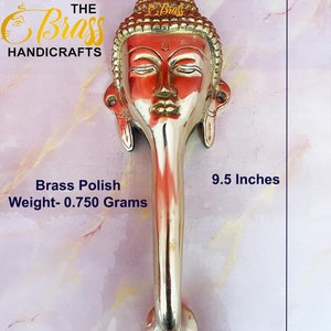 May include: Brass door handle with a Buddha head design. The handle is 9.5 inches long and 3.5 inches wide. The handle is made of brass and has a polished finish. The weight of the handle is 0.750 grams.