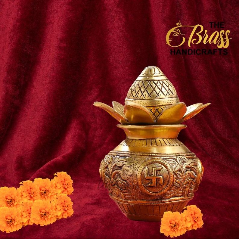 Peut inclure: Un pot en laiton dor&eacute; avec un couvercle d&eacute;coratif et des accents en forme de lotus. Le pot pr&eacute;sente des gravures complexes et un symbole sur le devant. Le fond est un tissu rouge fonc&eacute;, avec des fleurs orange au premier plan. Le logo The Brass Handicrafts est en haut &agrave; droite.