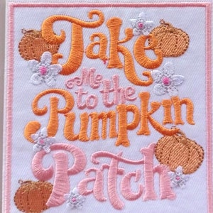 May include: Embroidered patch with the text "Take Me to the Pumpkin Patch" in orange and pink. The design includes pumpkins and flowers. The patch is bordered with a pink outline on a white background.