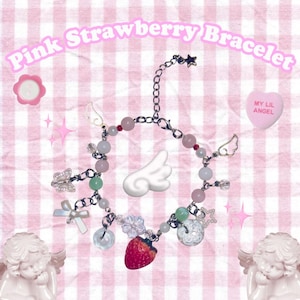 Pu&ograve; includere: Un braccialetto rosa con la scritta "Pink Strawberry Bracelet". Il braccialetto presenta perline rosa e verdi, un ciondolo a forma di fragola rossa, ciondoli ad ali d'angelo e un ciondolo a farfalla. Lo sfondo &egrave; un motivo a scacchi rosa e bianco.