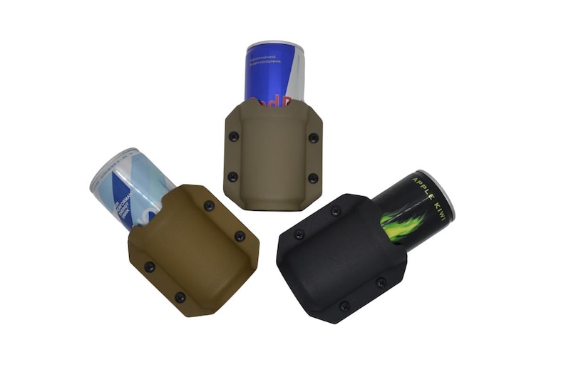 May include: Three beverage can holders in tan, brown, and black. Each holder has a rectangular shape with rounded corners and is secured with black rivets. Cans of Red Bull and other beverages are visible in the holders.
