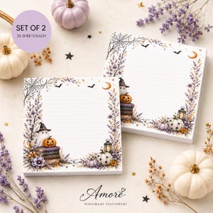 May include: A set of two square stationery pads, each containing 25 sheets. The paper features horizontal lines and a decorative border with illustrations of a ghost in a witch hat, pumpkins, a spider web, a lantern, and purple flowers.