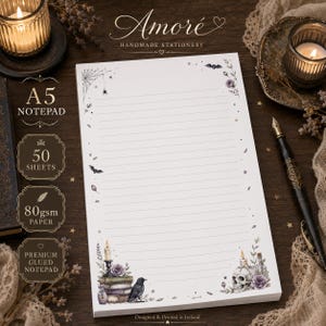 May include: An A5 notepad with 50 sheets of 80gsm paper, featuring horizontal lines and decorative borders. The design includes illustrations of a spider web, bats, stars, a stack of books, a candle, a raven, and a skull with purple flowers.