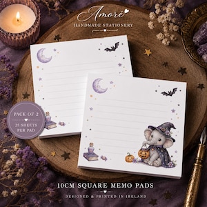 May include: Two square memo pads measuring 10cm each, featuring a Halloween theme with a cartoon elephant in a witch hat, a pumpkin, a crescent moon, stars, and a bat. Each pad contains 25 sheets with horizontal lines and printed illustrations.