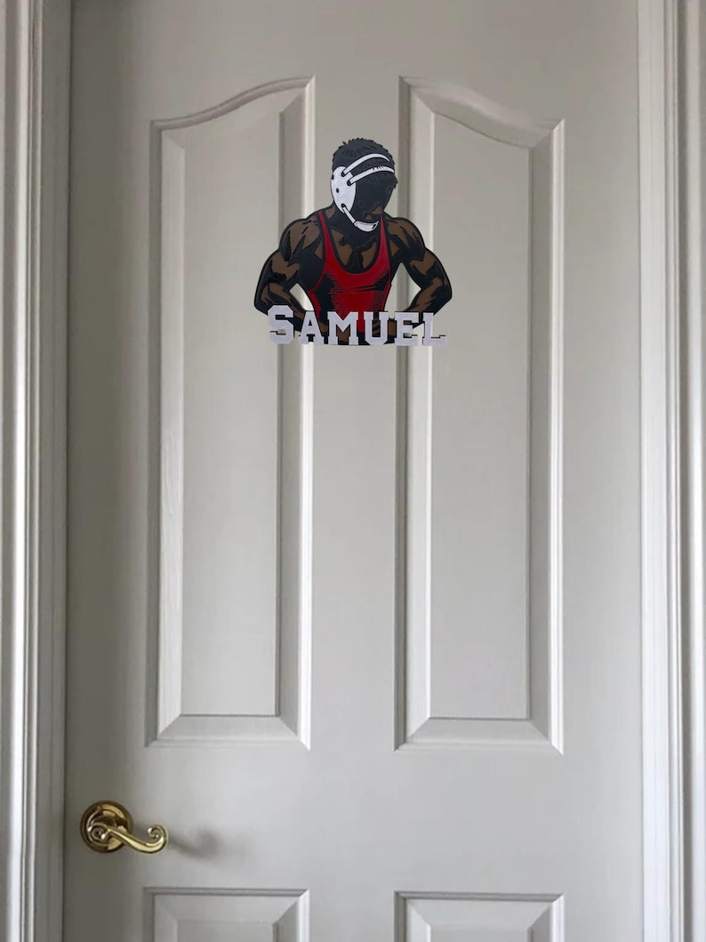 Puede incluir: Una puerta blanca con una manija de puerta dorada. Un gr&aacute;fico de luchador con el nombre "SAMUEL" est&aacute; pegado a la puerta.