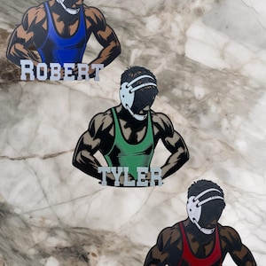 Puede incluir: Tres siluetas de luchadores con los nombres "Robert", "Tyler" y "Samuel". Los luchadores llevan singletes de lucha de diferentes colores: azul, verde y rojo.
