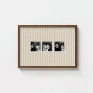 May include: A rectangular wooden picture frame containing three square black and white photographs of people. The matting inside the frame features a vertical beige and white striped pattern, providing a textured backdrop for the three images.