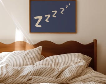 May include: A bedroom scene featuring a wooden headboard and a bed with striped bedding. A framed navy blue print on the wall displays the word "Zzz" in a whimsical font. The room is bathed in soft, natural light, creating a cozy atmosphere.