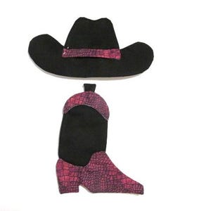 May include: A black cowboy hat with a pink band and a matching cowboy boot with a pink snakeskin pattern. The boot has a black upper and a pointed toe. The hat and boot are set against a white background.