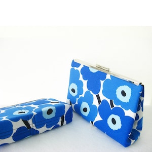 Pu&ograve; includere: Due pochette in tessuto con stampa floreale blu e bianca con chiusura in metallo argentato. La pochette pi&ugrave; grande ha un design floreale pi&ugrave; prominente.