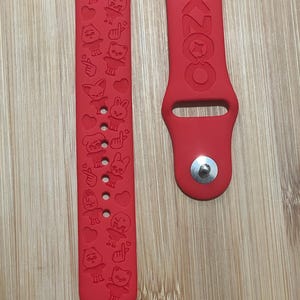 Könnte beinhalten: Rotes Silikonarmband für Apple Watch mit einem weißen Design mit Comicfiguren und dem Wort "SKZOO".