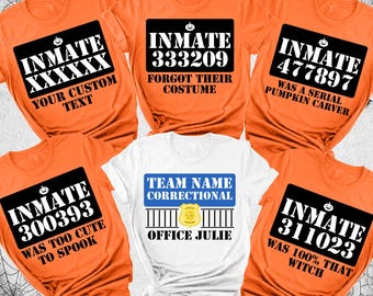 May include: Orange and white Halloween-themed t-shirts. The orange shirts feature inmate-style designs with numbers and phrases like "Forgot Their Costume" and "Was 100% That Witch." One shirt is white with "Team Name Correctional" and "Office Julie."