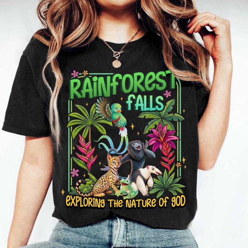 May include: Black t-shirt with a colorful rainforest graphic. The design includes a parrot, lemur, ocelot, frog, and anteater, with the text "Rainforest Falls" and "Exploring the Nature of God."