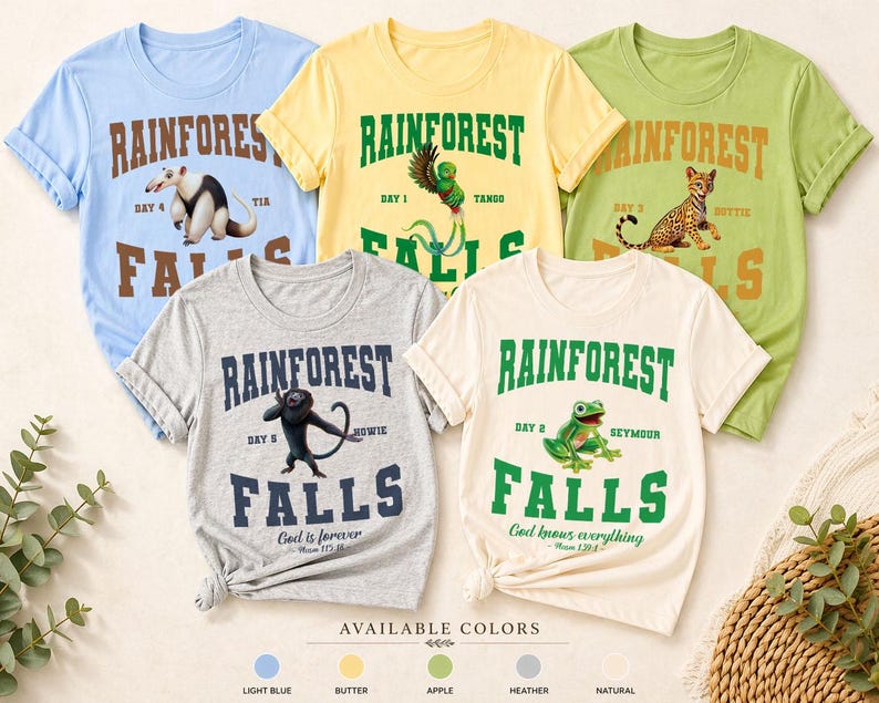 May include: Five colorful t-shirts with rainforest-themed designs. Each shirt features the text "Rainforest Falls" with a different animal illustration and the words "Day" and a name. Available in light blue, butter, apple, heather, and natural.