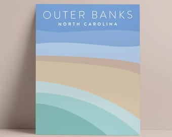 May include: A rectangular art print featuring a minimalist beach scene. The artwork displays layered bands of color, including light blue, tan, and teal, with the words "Outer Banks North Carolina" in white at the top.