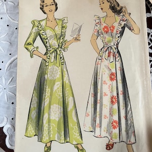 May include: A vintage Du Barry Patterns sewing envelope featuring illustrations of two floor-length dresses with ruffled shoulders, V-necklines, and waist ties. The text reads Du Barry Patterns 15 cents, Bust 36, Hip 39, and Copyright 1944 by Du Barry Patterns Ltd.
